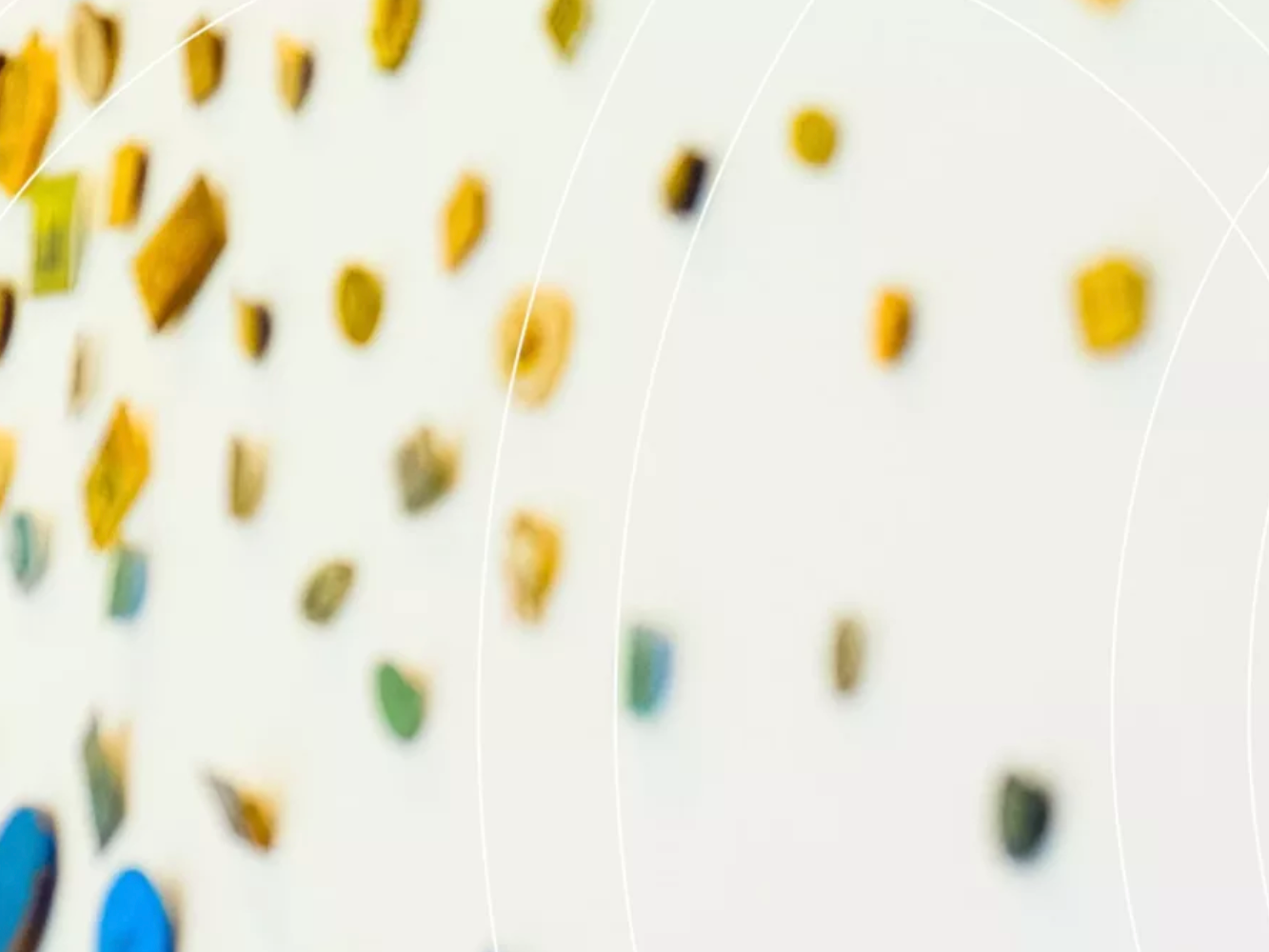 Unschärfeaufnahme einer hellen Wand mit bunten Klettergriffen.