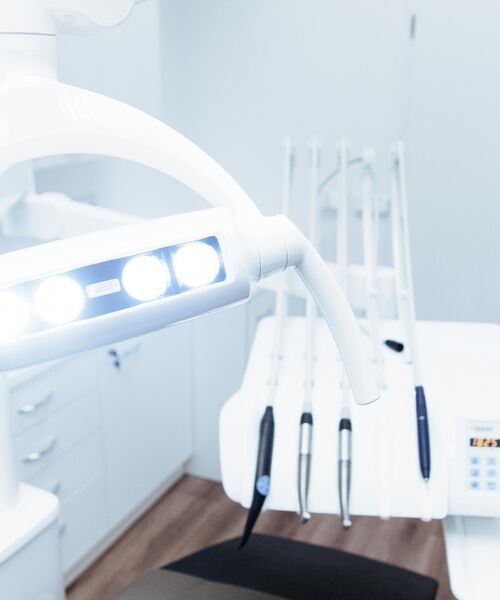 Heller Behandlungsraum mit Zahnarztstuhl, Lampe und Instrumenten – Symbol für moderne zahnmedizinische Ausstattung.