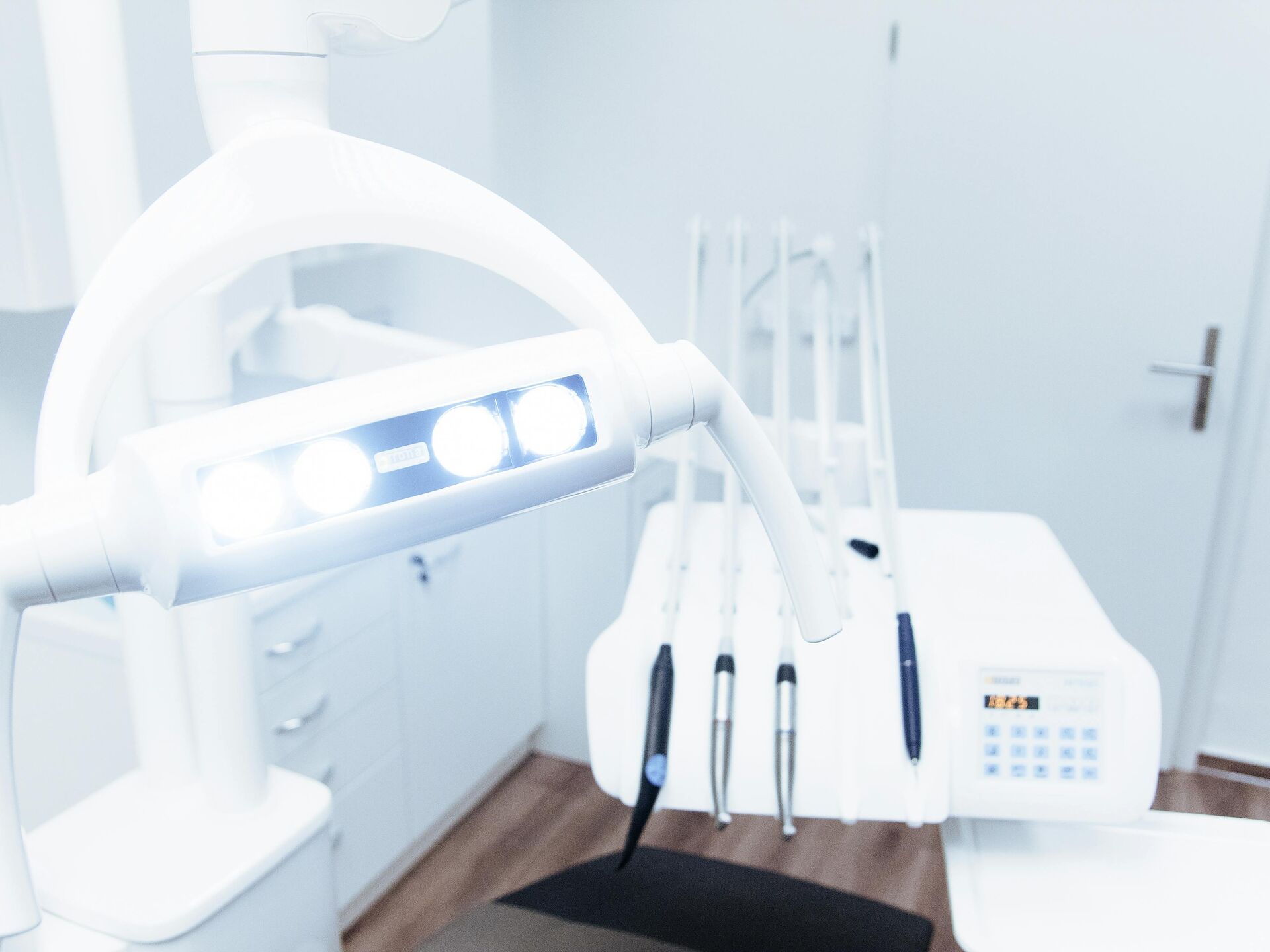 Heller Behandlungsraum mit Zahnarztstuhl, Lampe und Instrumenten – Symbol für moderne zahnmedizinische Ausstattung.