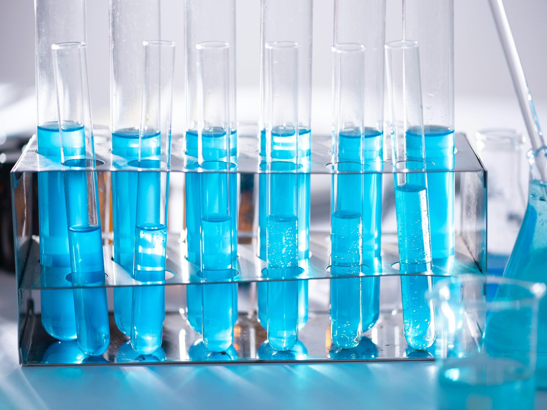 Reagenzgläser mit blauer Flüssigkeit in einem Ständer – Symbol für Laborarbeit, Forschung und chemische Analyse.
