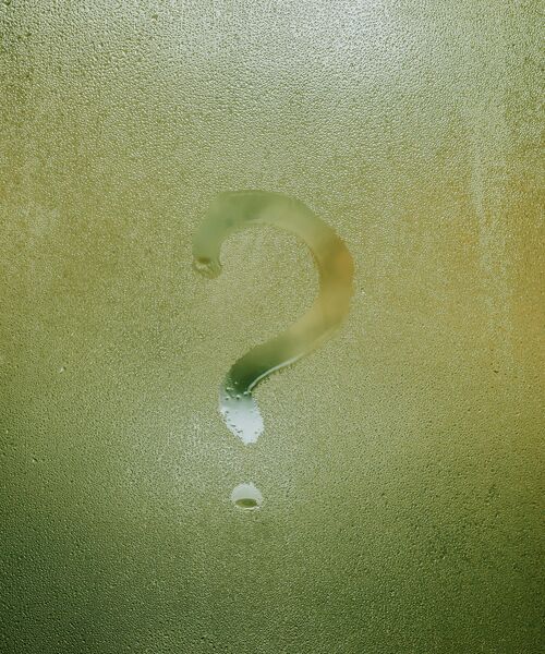 Fragezeichen auf beschlagener Glasscheibe gezeichnet – Symbol für Neugier, Unklarheit oder Nachdenken.